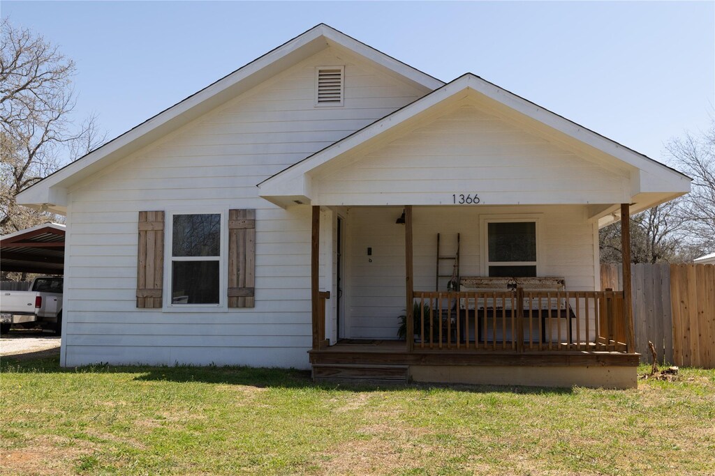 view of front of house featuring fence, a front yard, and a porch