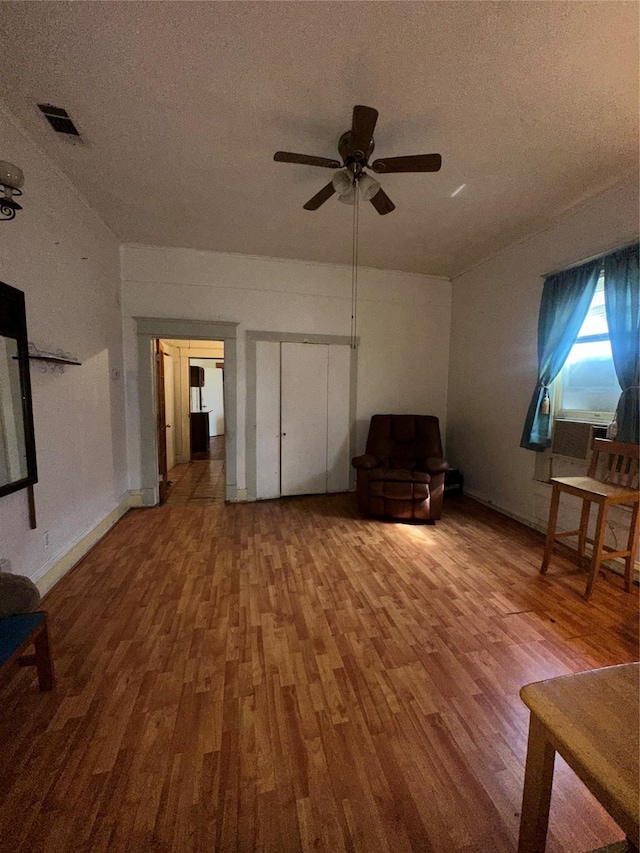 interior space with visible vents, ceiling fan, wood finished floors, and a textured ceiling