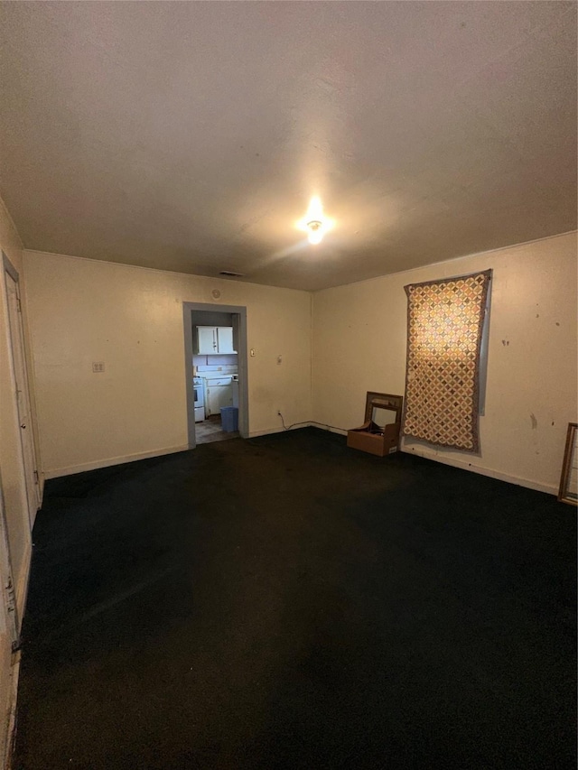 unfurnished room featuring baseboards and carpet