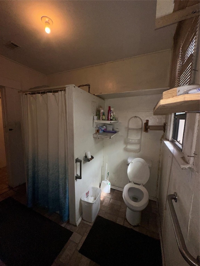bathroom with toilet, curtained shower, and visible vents