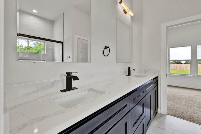full bath featuring marble finish floor, a healthy amount of sunlight, and a sink