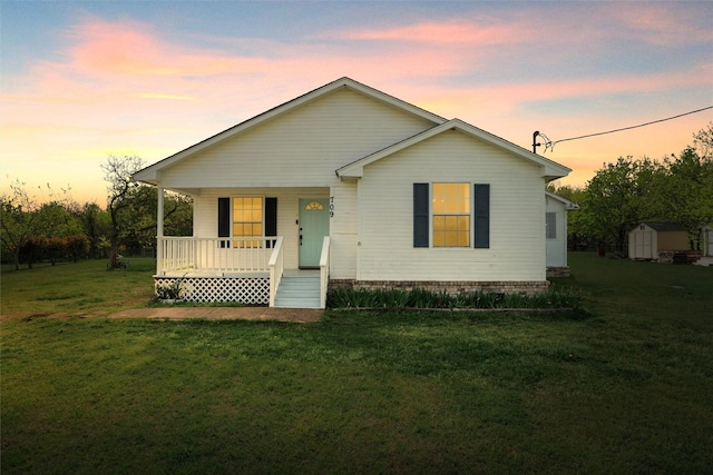 709 Verde Dr, Burleson, TX 76028 - view of front of home with a storage shed, covered porch, a front yard, and an outdoor structure