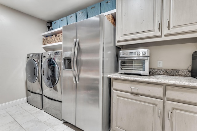 clothes washing area featuring baseboards, cabinet space, separate washer and dryer, and a toaster