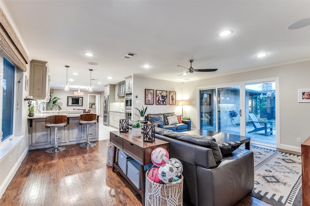 living room with ornamental molding, dark wood-style floors, visible vents, ceiling fan, and recessed lighting