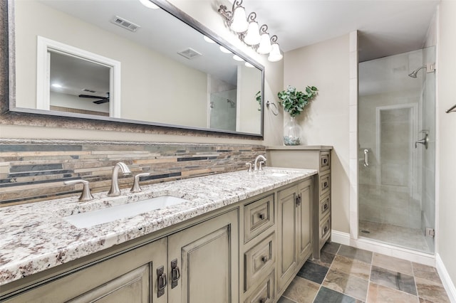bathroom featuring a shower stall, visible vents, decorative backsplash, and a sink