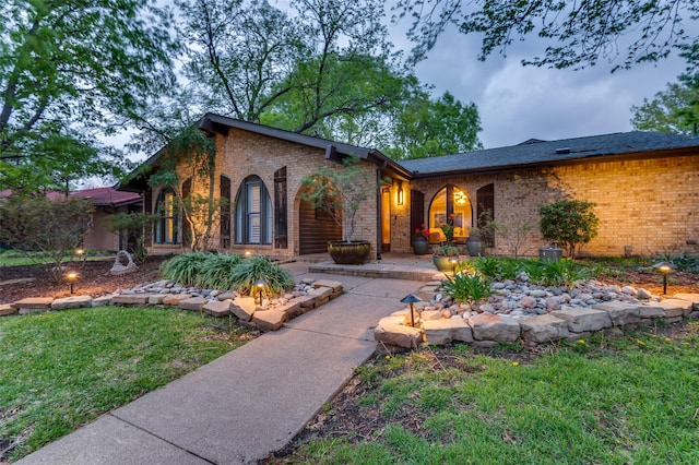 mid-century home with brick siding and a front lawn