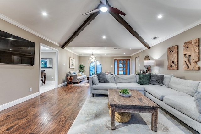 living room featuring lofted ceiling with beams, visible vents, baseboards, ornamental molding, and wood finished floors