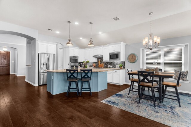 5604 Datewood Ln, Mckinney, TX 75071 - kitchen with stainless steel appliances, arched walkways, a chandelier, white cabinets, and recessed lighting
