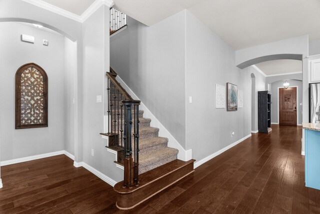 5604 Datewood Ln, Mckinney, TX 75071 - entryway featuring arched walkways, dark wood finished floors, baseboards, and ornamental molding