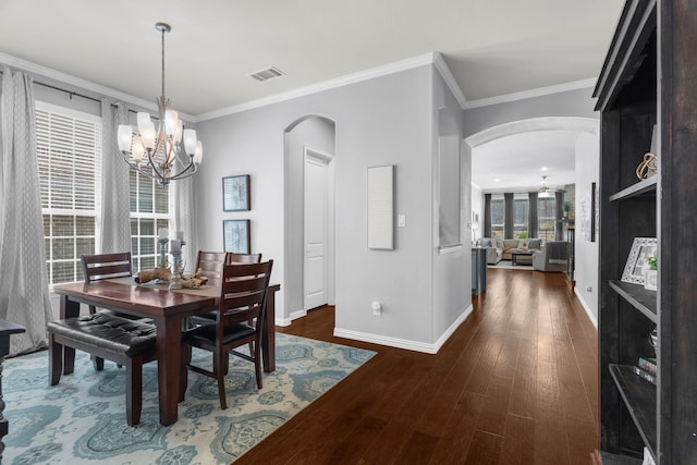 5604 Datewood Ln, Mckinney, TX 75071 - dining room with arched walkways, baseboards, a chandelier, wood finished floors, and crown molding