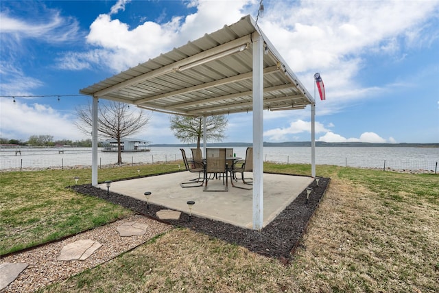 view of patio / terrace with a water view and fence