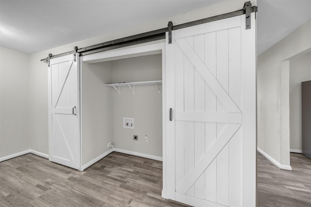 600 N Mill St, Bowie, TX 76230 - washroom with a barn door, electric dryer hookup, hookup for a washing machine, and wood finished floors