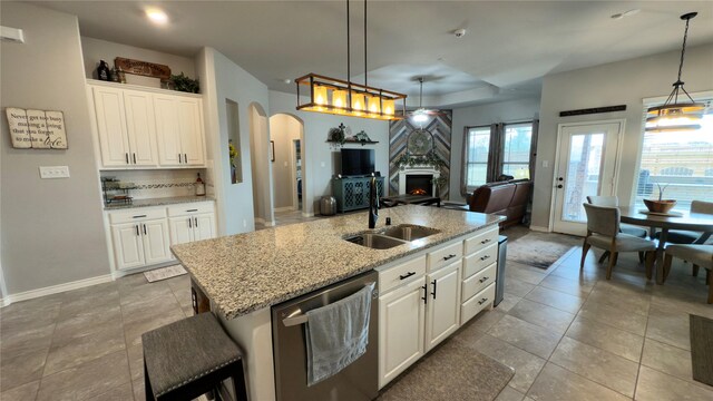 living area with a ceiling fan, arched walkways, light tile patterned floors, baseboards, and recessed lighting