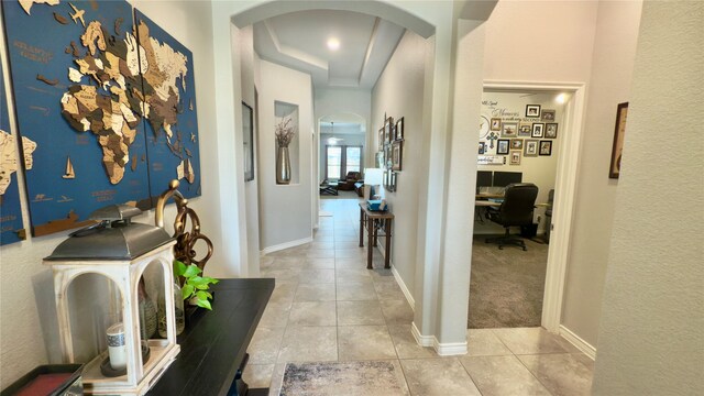 kitchen with backsplash, arched walkways, light stone countertops, a sink, and stainless steel appliances