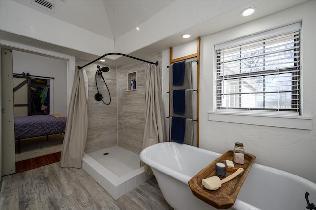 full bath featuring recessed lighting, a shower stall, visible vents, a freestanding bath, and wood finished floors
