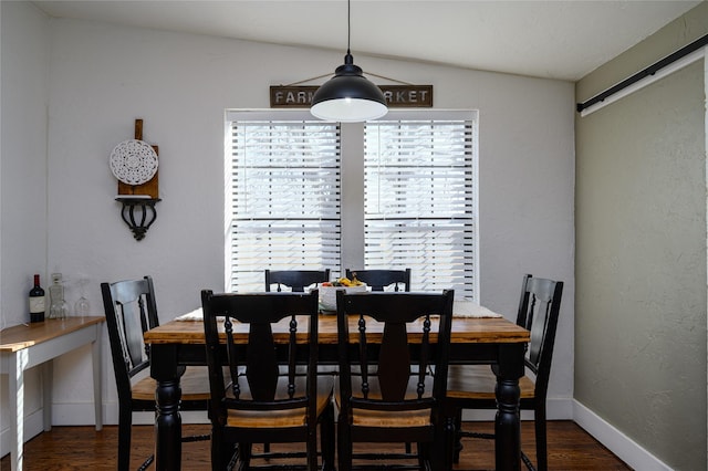 dining room with baseboards, a textured wall, and wood finished floors