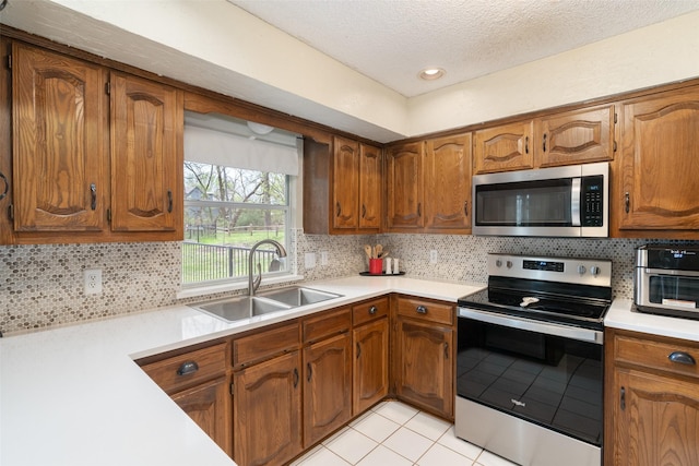 1 Cedar Bend Trl, Lucas, TX 75002 - kitchen featuring appliances with stainless steel finishes, a sink, light tile patterned floors, light countertops, and a textured ceiling
