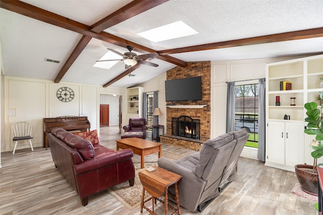 1 Cedar Bend Trl, Lucas, TX 75002 - living room with a skylight, a brick fireplace, light wood-style floors, ceiling fan, and a textured ceiling