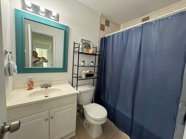 full bathroom featuring tile patterned flooring, vanity, toilet, a textured wall, and a textured ceiling