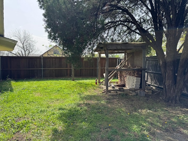 view of yard with a fenced backyard and an outbuilding