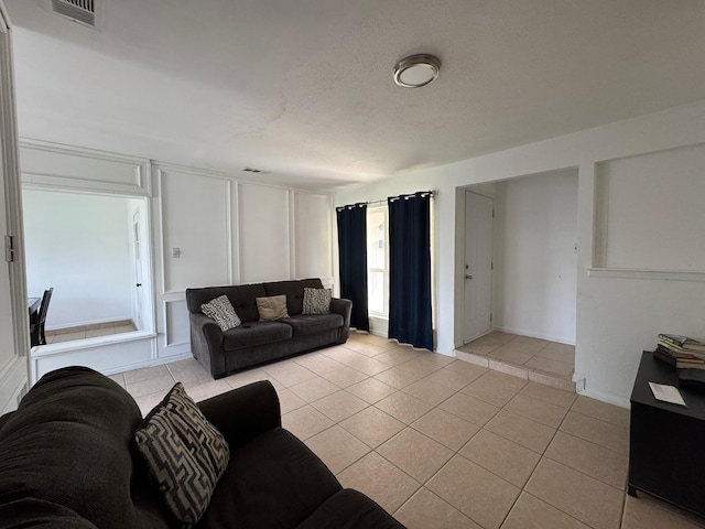 living area with visible vents and light tile patterned floors