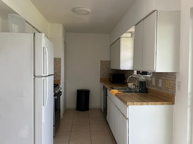 kitchen with a sink, decorative backsplash, black appliances, and light tile patterned flooring