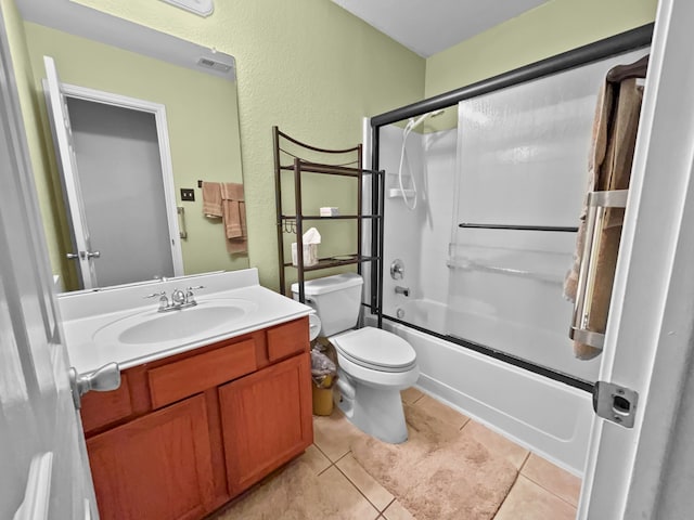 bathroom with toilet, tile patterned floors, vanity, combined bath / shower with glass door, and a textured wall