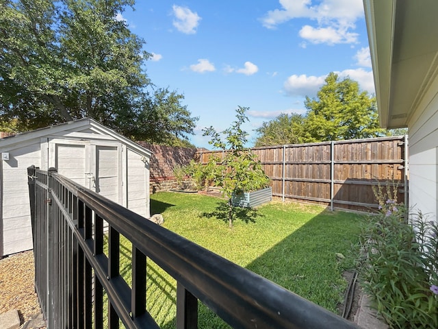 view of yard featuring a fenced backyard, a shed, and an outbuilding