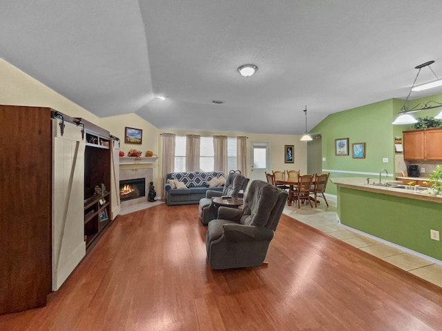 living room with lofted ceiling, light wood finished floors, and a fireplace