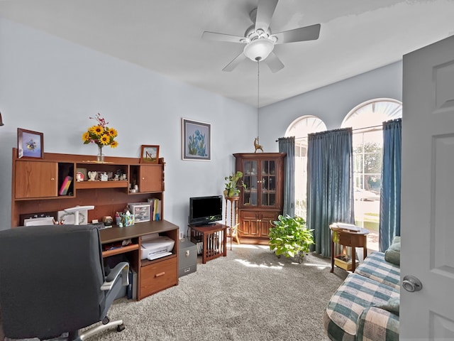 carpeted office space with a ceiling fan