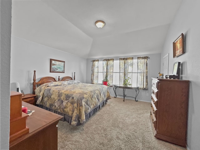 carpeted bedroom with vaulted ceiling and baseboards