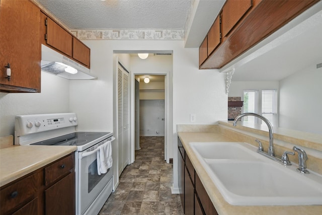5912 Oregon Trl Ct, Haltom City, TX 76148 - kitchen with light countertops, under cabinet range hood, a textured ceiling, white range with electric cooktop, and a sink
