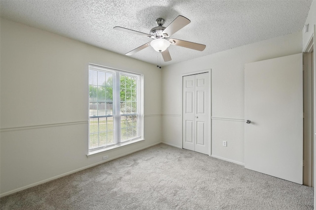 5912 Oregon Trl Ct, Haltom City, TX 76148 - unfurnished bedroom with a ceiling fan, carpet floors, a closet, and a textured ceiling