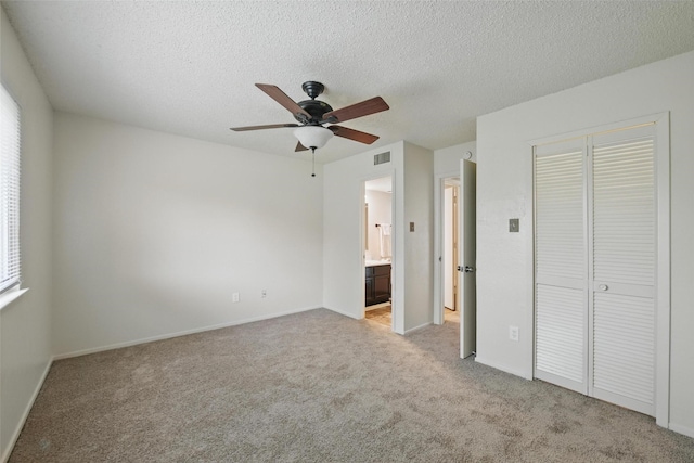 5912 Oregon Trl Ct, Haltom City, TX 76148 - unfurnished bedroom featuring light colored carpet, a textured ceiling, ensuite bath, visible vents, and a closet