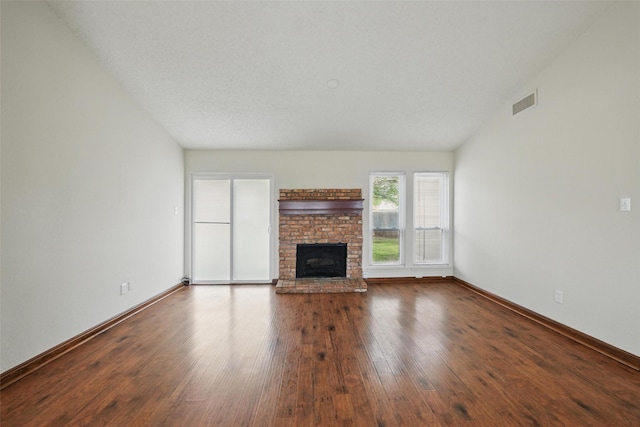 5912 Oregon Trl Ct, Haltom City, TX 76148 - unfurnished living room featuring baseboards, visible vents, a fireplace, and hardwood / wood-style floors