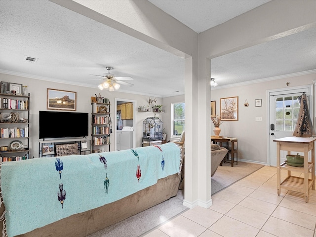 living room with ceiling fan, a textured ceiling, visible vents, light tile patterned floors, and ornamental molding