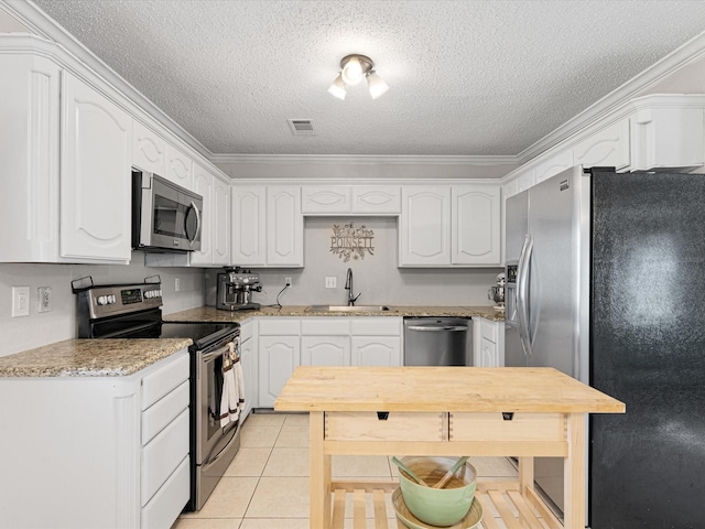 kitchen with ornamental molding, a textured ceiling, white cabinetry, a sink, and appliances with stainless steel finishes
