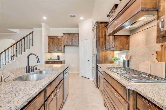 9836 Arctic Dr, Frisco, TX 75035 - kitchen with a sink, premium range hood, stainless steel appliances, light stone counters, and crown molding