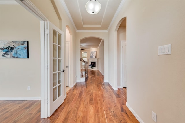 9836 Arctic Dr, Frisco, TX 75035 - hallway featuring arched walkways, light wood finished floors, crown molding, and baseboards