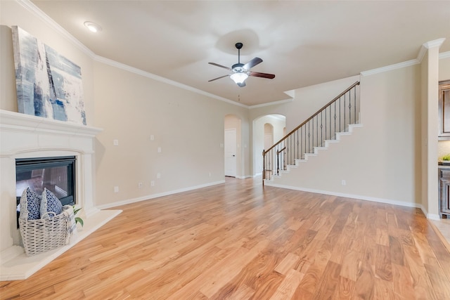 9836 Arctic Dr, Frisco, TX 75035 - unfurnished living room featuring arched walkways, ceiling fan, stairs, light wood finished floors, and ornamental molding