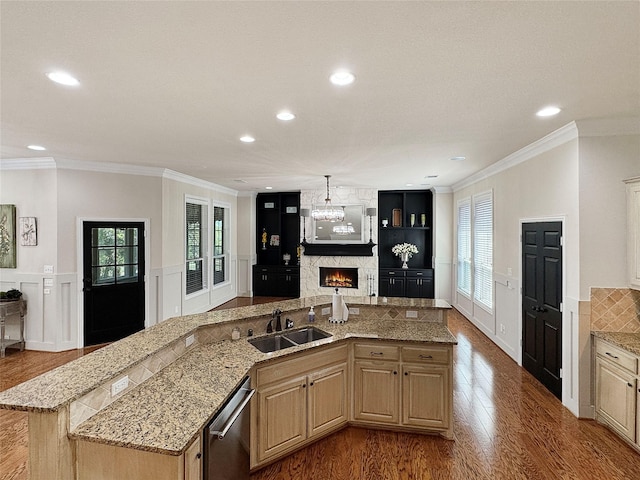 kitchen with a sink, open floor plan, ornamental molding, dark wood-style floors, and recessed lighting