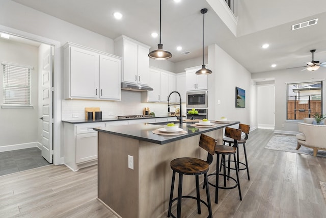 kitchen featuring baseboards, visible vents, dark countertops, and backsplash