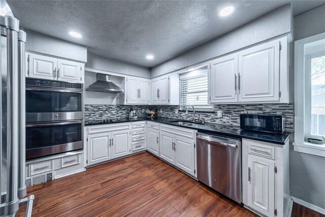 6110 Caracas Dr, Dallas, TX 75232 - kitchen with black appliances, wall chimney range hood, dark countertops, a sink, and dark wood finished floors