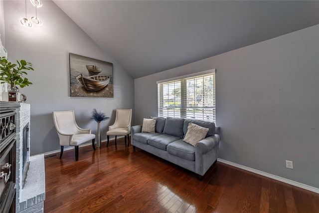 6110 Caracas Dr, Dallas, TX 75232 - living area featuring baseboards, lofted ceiling, hardwood / wood-style flooring, and a brick fireplace