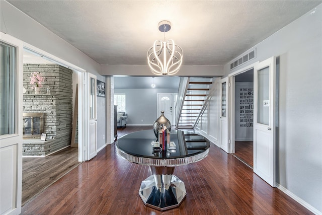 6110 Caracas Dr, Dallas, TX 75232 - dining room featuring visible vents, a notable chandelier, a fireplace, and wood finished floors
