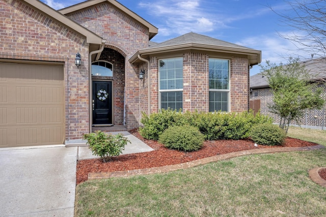 560 Camber St, Saginaw, TX 76131 - view of exterior entry with an attached garage, concrete driveway, and brick siding
