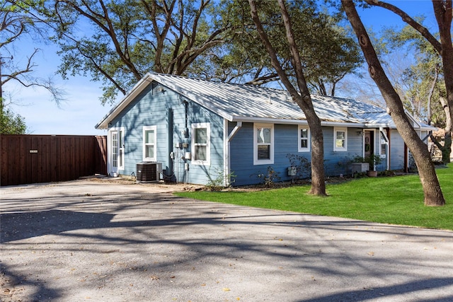 106 Gawayne Dr, Mabank, TX 75156 - view of front facade featuring central air condition unit, fence, metal roof, aphalt driveway, and a front yard