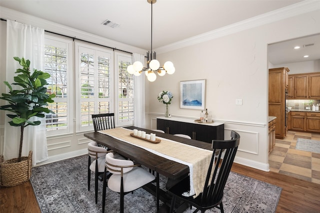 1715 San Jacinto Dr, Allen, TX 75013 - dining area featuring light wood-style floors, crown molding, a decorative wall, a chandelier, and wainscoting