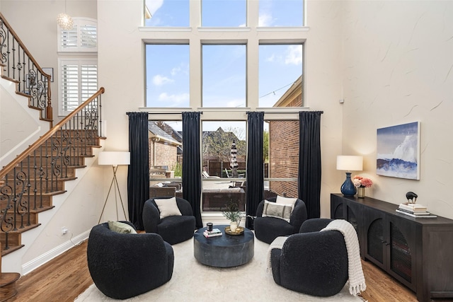 1715 San Jacinto Dr, Allen, TX 75013 - sitting room featuring a towering ceiling, wood finished floors, stairs, healthy amount of natural light, and baseboards