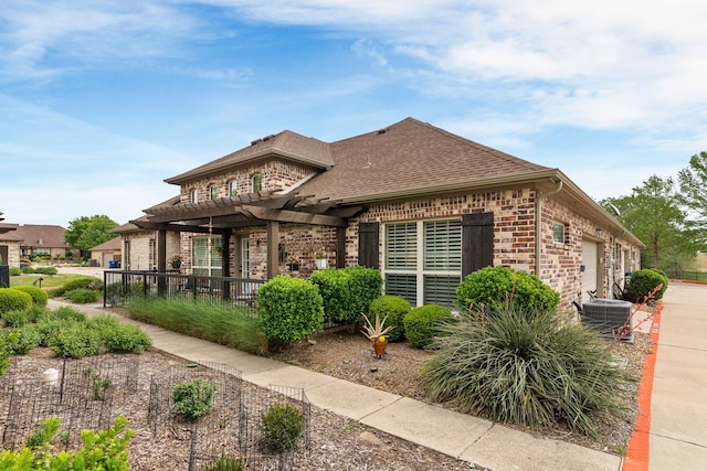 back of house featuring a pergola, roof with shingles, cooling unit, brick siding, and a garage